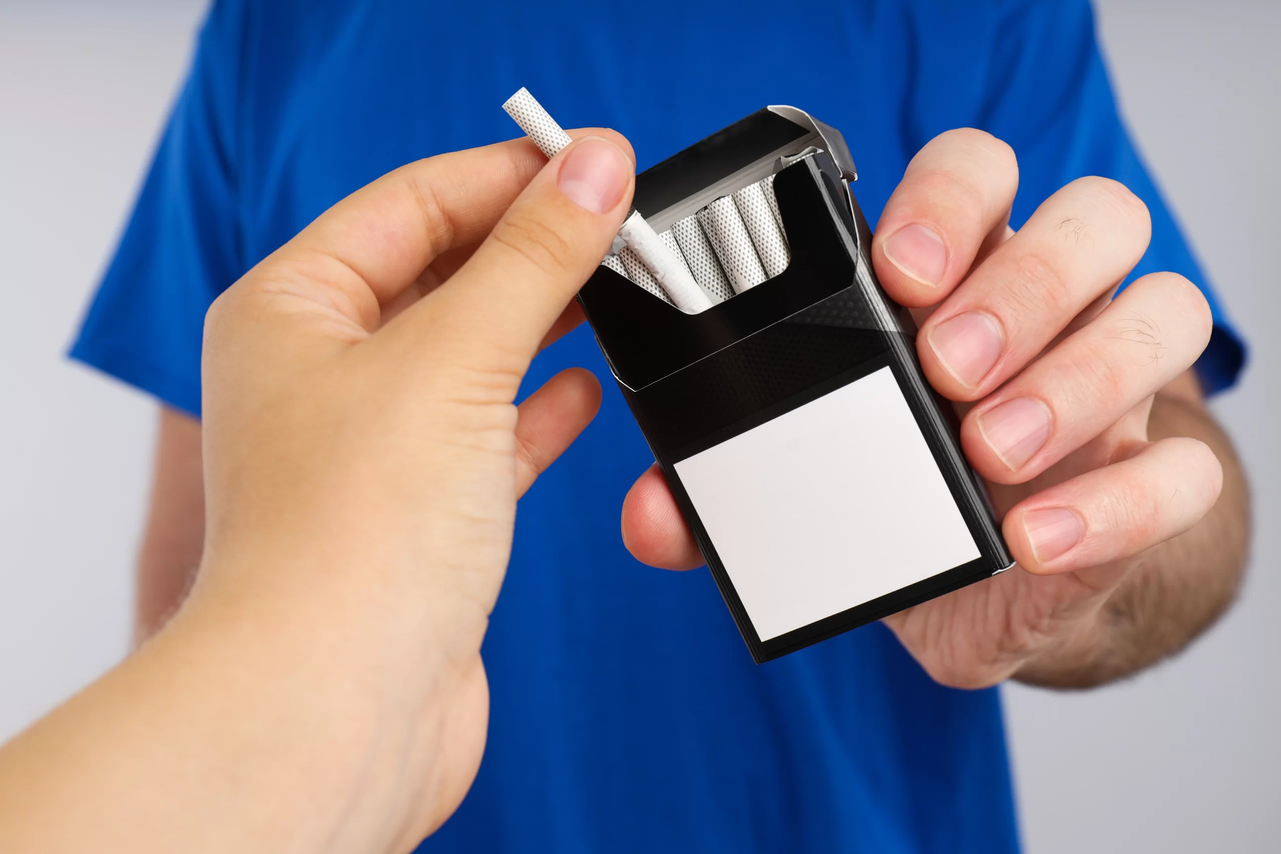 pack-cigarettes-hands-man-blue-tshirt